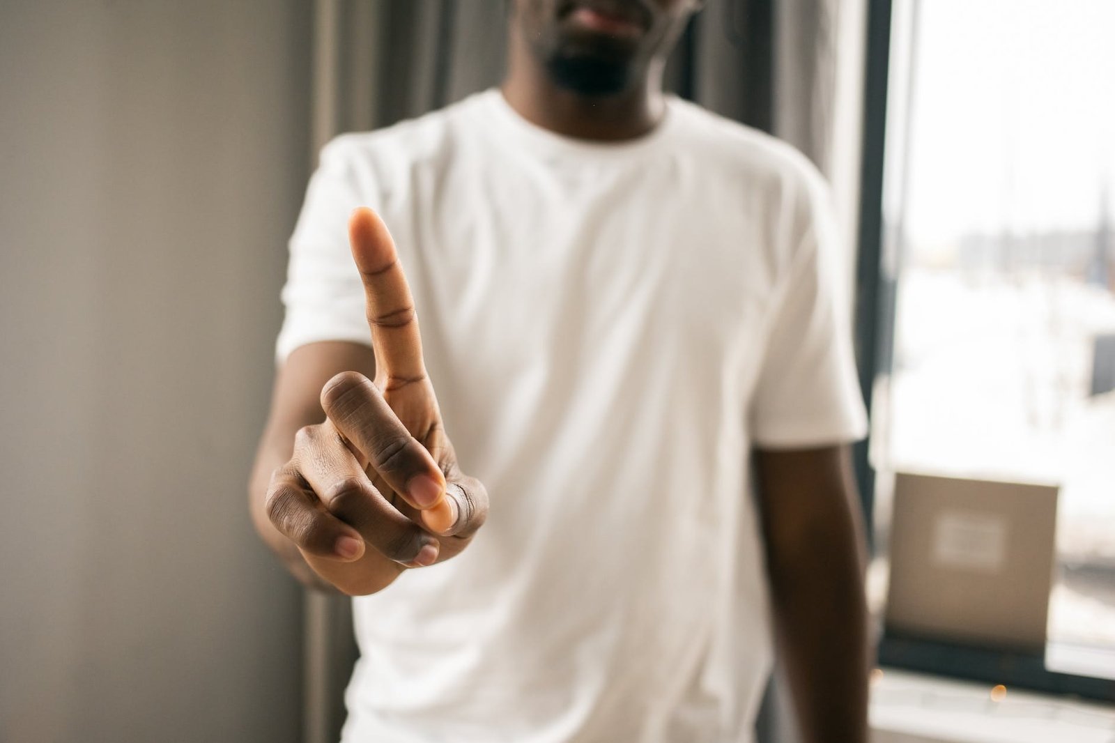 unrecognizable black man showing no sign with index finger